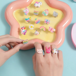 Adjustable kids unicorn ring set with colorful cartoon shapes on a pink star tray