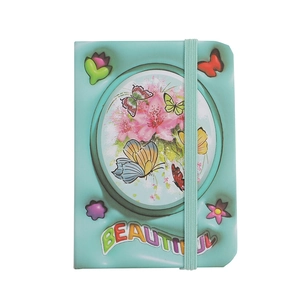 Close-up of a mint green pocket notebook with butterfly floral design and elastic band