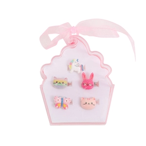 Close-up of five cartoon rings including unicorn and rainbow shapes in a cupcake box
