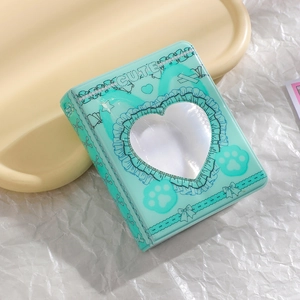 Close-up of mint green K-pop photocard album featuring a heart-shaped cutout and lace details