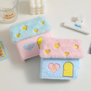 Détail d'albums photos en peluche en forme de maison avec broderie cœur et couleurs pastels