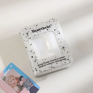 Macro shot of a white ink-splatter photocard binder with square window and Heartbeat text