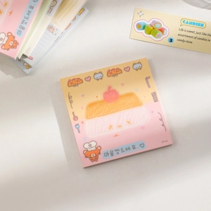 Close-up of cute cartoon notepad with bear and pudding illustrations in soft yellow and pink