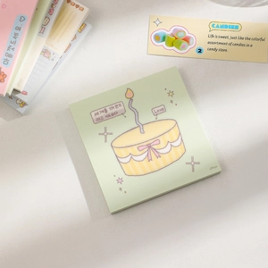 Close-up of square notepad with cute dessert illustration and green pastel paper background