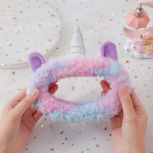 Détail du bandeau licorne en peluche montrant la texture douce et la corne argentée