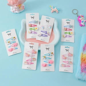 Dettaglio di set 4 mollette per capelli con unicorno e arcobaleno su scheda espositiva