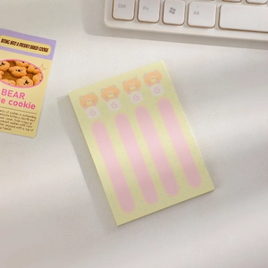 Close-up of cute cartoon bear sticky notes with pink accents on a yellow dotted background