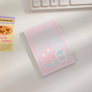 Close-up of pink sticky notes with cartoon bunny and house illustrations on a desk
