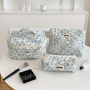 Three-piece blue floral quilted cotton toiletry bag set with top handle and cosmetic pouches