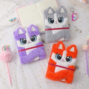Close-up of plush cat journals with metal locks and fluffy pens on star patterned tulle