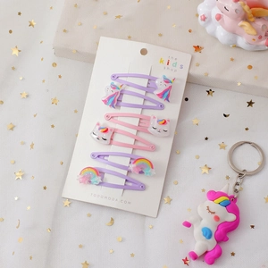 Dettaglio di 6 fermagli per capelli unicorno e arcobaleno su carta con sfondo glitterato