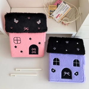 Detail of plush house-shaped A5 photo albums with cute embroidery on white desk