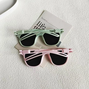 Detail of vintage square sunglasses in green and pink with unique mechanical hinge design