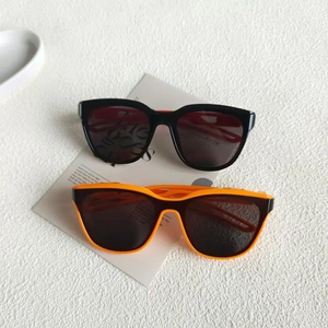 Detailed view of square hollow sunglasses in black and orange on a clean white background