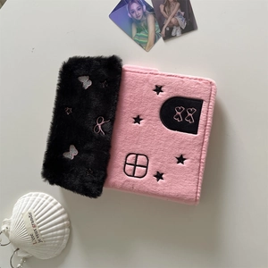 Detailed view of pink and black plush card binder with star and butterfly embroidery