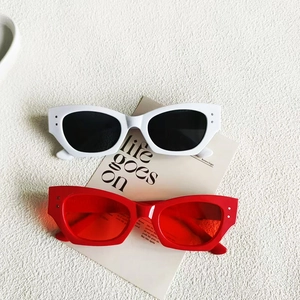 Flat lay of vintage cat eye sunglasses in white and transparent red with silver rivets