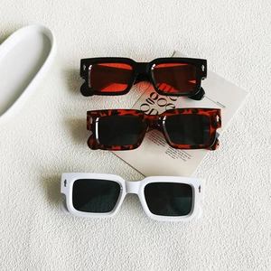 Gros plan de lunettes de soleil carrées rétro avec rivets fléchés argentés en trois couleurs