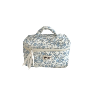 Blue floral quilted makeup bag with handle and ribbon zipper for cosmetic storage