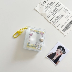 Close-up of a mini transparent PVC photo album with a yellow clasp and cute bear card