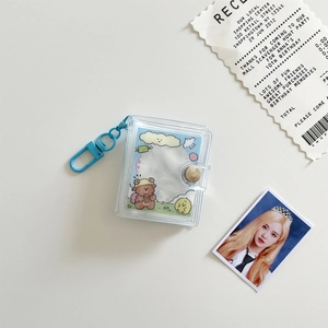 Close-up of mini transparent PVC photo album with a bright blue clasp and cute bear card