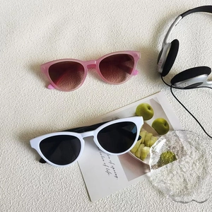 Retro cat-eye sunglasses in pink and white frames with a stylish vintage aesthetic