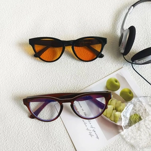 Close-up of retro black frame sunglasses with orange lenses and tortoise shell frames