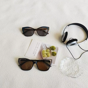 Retro cat-eye sunglasses with contrast color frames on minimalist textured background