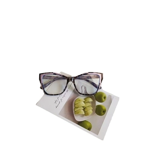 Retro cat-eye sunglasses with tortoiseshell frame and pink accents on display card