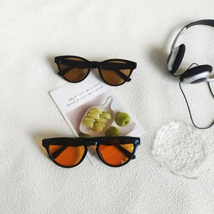 Retro-Katzenaugen-Sonnenbrille mit schwarzem Rahmen und getönten Gläsern auf weißem Grund