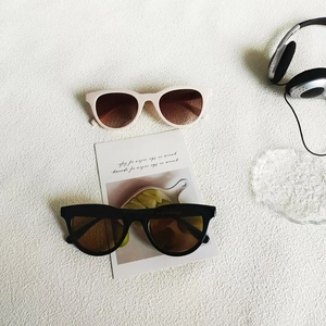 Flat lay of vintage cat-eye sunglasses in black and cream with UV400 lenses