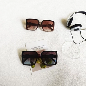 Détail de lunettes de soleil carrées oversize en écaille et noir avec verres dégradés
