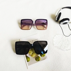 Gros plan de lunettes de soleil carrées oversize en violet dégradé et noir classique