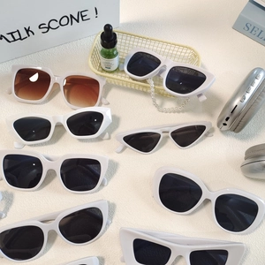 Variety of white oval sunglasses and cat eye sun glasses for women in a lifestyle layout