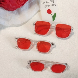 Trois styles de lunettes de soleil rouges transparentes sur un fond décoratif floral
