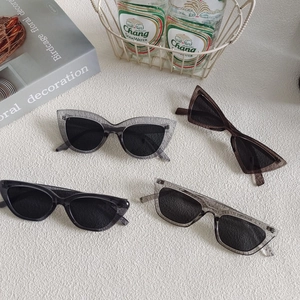 Detail of four retro square sunglasses with translucent stone texture on a white surface
