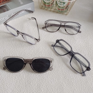 Retro square gray sunglasses and transparent optical frames set on beige background