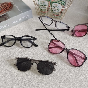 Modern gray and black square frame sunglasses set displayed in a flat lay lifestyle view