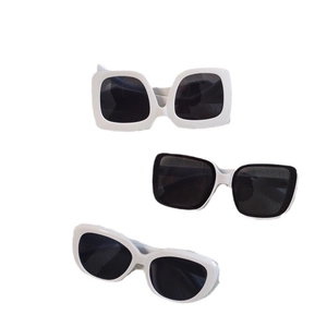 Three pairs of white and black oval sunglasses with thick frames and dark lenses in a group