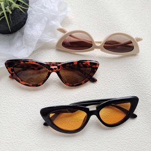 Three pairs of vintage cat-eye sunglasses in beige, tortoiseshell, and black frames