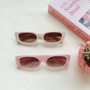 Flat lay of square vintage sunglasses in beige and pink tones with retro frames
