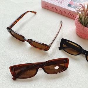 Three pairs of vintage square sunglasses in tortoiseshell, amber, and black colors