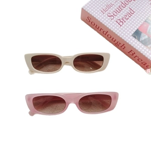 Minimalist square retro sunglasses in beige and soft pink colors on a warm scene background