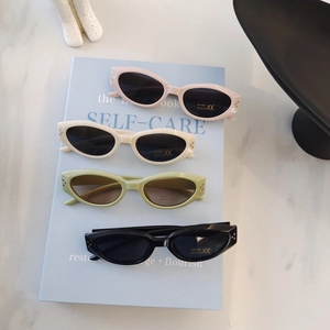 Set of four colorful oval kids sunglasses with UV400 protection on blue books