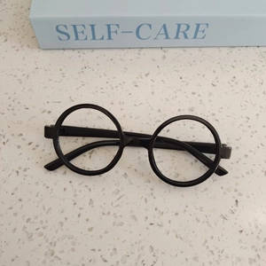 Close-up of black round-frame glasses for kids on a modern terrazzo surface