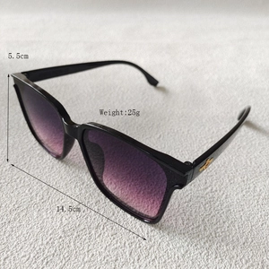 Détail de lunettes de soleil oversize avec verres dégradés violets et décor papillon doré