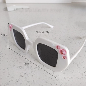 Detail view of kids white sunglasses with pink rhinestones and size dimensions
