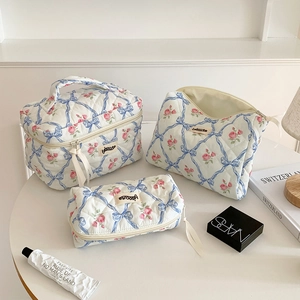 Ensemble de trois trousses de maquillage matelassées à motif floral avec grand étui