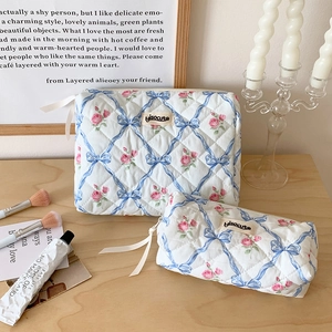 Détail de l'ensemble trousse maquillage en coton matelassé aux nœuds bleus et roses