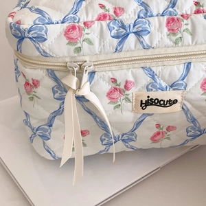 Gros plan détaillé d'une trousse de maquillage matelassée aux motifs roses et nœuds
