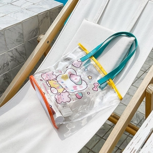Detail of a transparent cartoon bear beach bag with bright yellow handles on a beach chair
